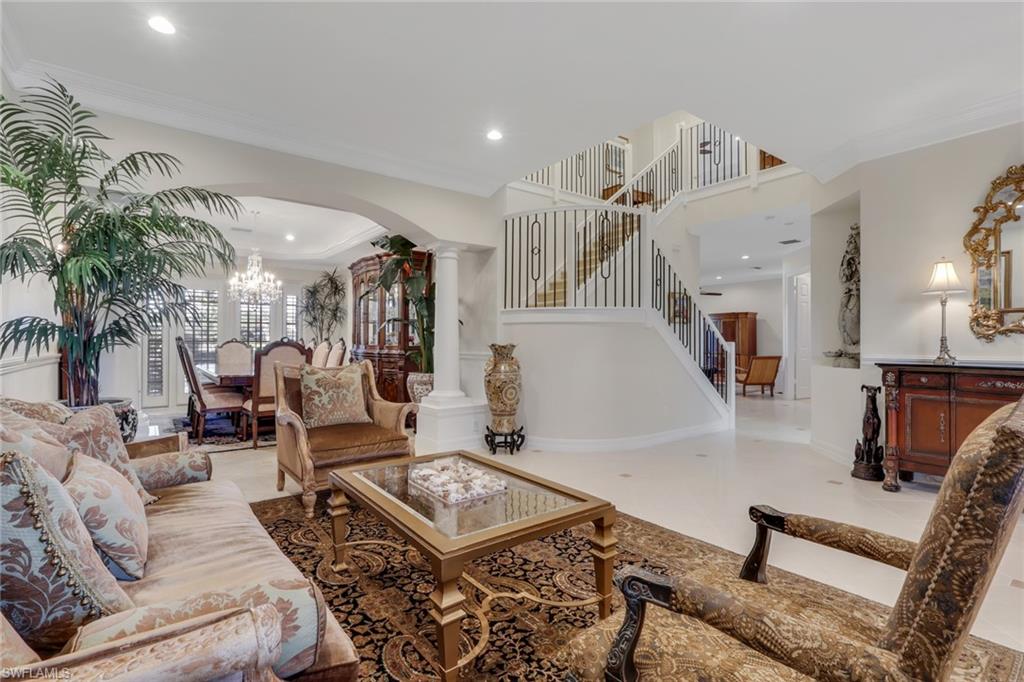 1859 Ivory Cane Point Naples, FL 34119 - Photo 8 of 50 Living area featuring ornamental molding, arched walkways, a chandelier, ornate columns, and recessed lighting