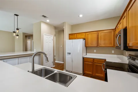 a kitchen with stainless steel appliances a refrigerator sink and microwave