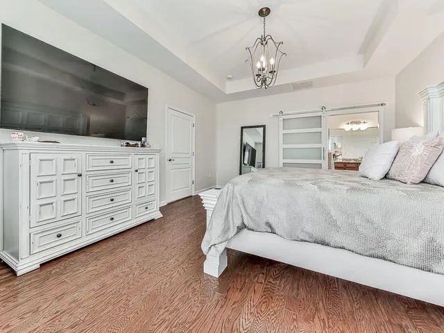 a bedroom with a bed couch and a flat tv screen