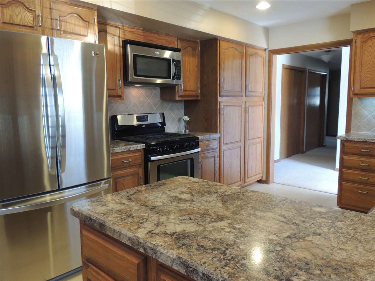 4114 Cushman Road Rockford, IL 61114 - Photo 6 of 25 a kitchen with kitchen island a counter top space stainless steel appliances and cabinets