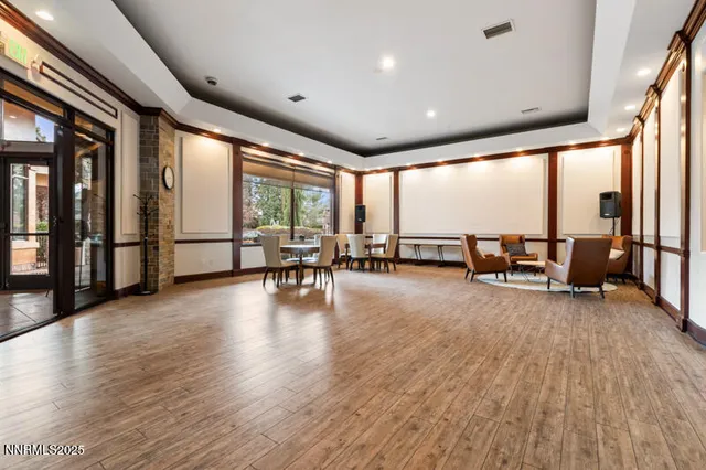 a view of an empty room with large windows and furniture