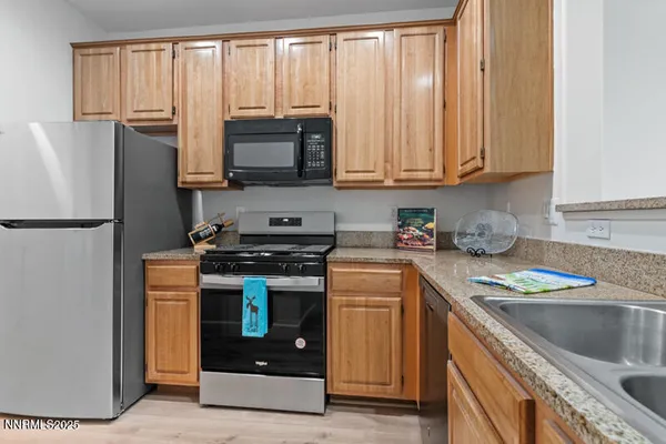 a kitchen with stainless steel appliances granite countertop a refrigerator stove and sink