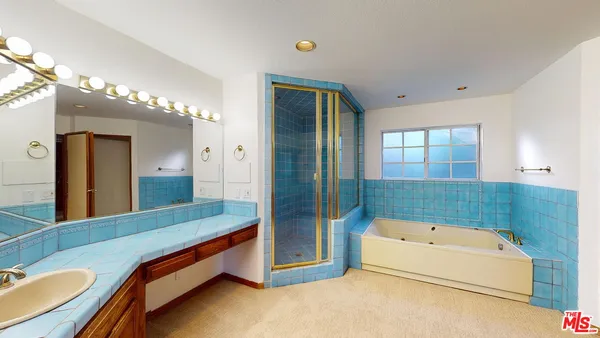 a bathroom with a tub a double vanity sink and mirror