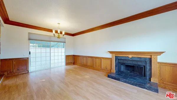 a view of empty room with wooden floor and fireplace
