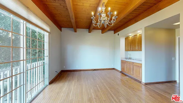 a view of a hallway with wooden floor and chandelier