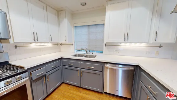 a kitchen with granite countertop a sink cabinets and stainless steel appliances