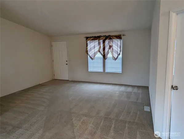 an empty room with windows and cabinet