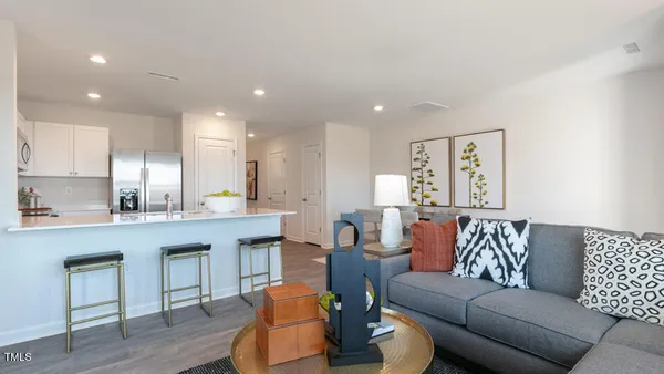 a living room with furniture and a kitchen view