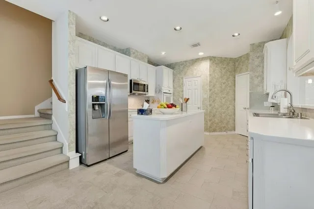 a kitchen with refrigerator and cabinets