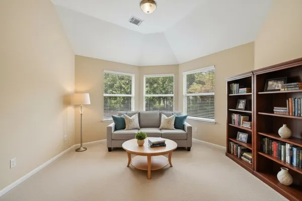 a living room with furniture and a book shelf