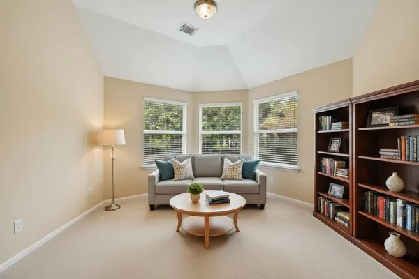 a living room with furniture and a book shelf