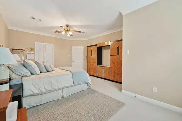 a spacious bedroom with a bed and a chandelier