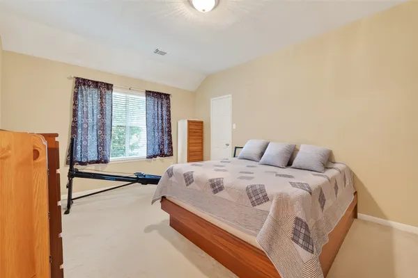 a spacious bedroom with a bed and a large window