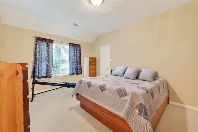 a spacious bedroom with a bed and a large window