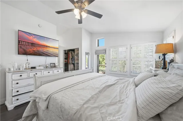 a bedroom with a large bed and a flat tv screen on dresser