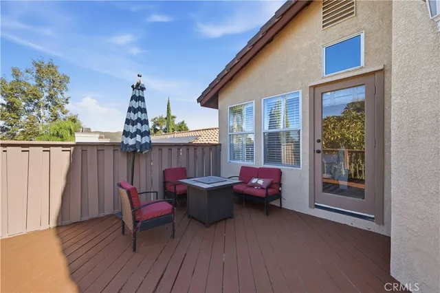 a view of a roof deck with table and chairs and wooden floor