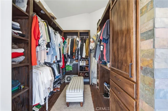 a view of walk in closet with clothes and shoes