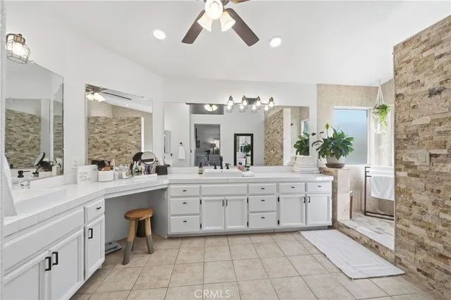 a large white kitchen with granite countertop a sink and white cabinets