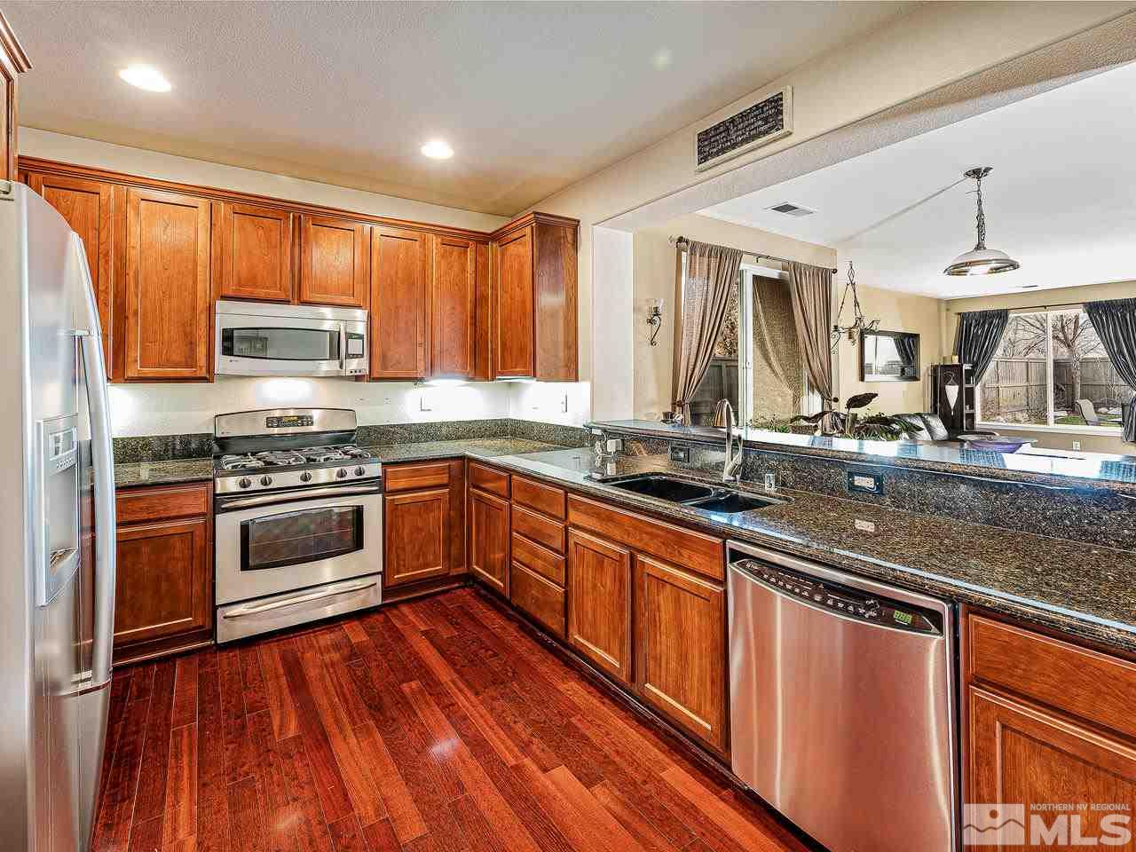 450 Alysheba Court Reno, NV 89521 - Photo 2 of 14 a kitchen with stainless steel appliances granite countertop a stove a sink and a microwave