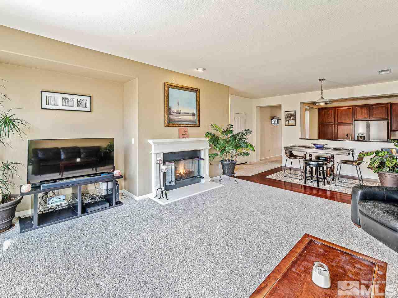 450 Alysheba Court Reno, NV 89521 - Photo 8 of 14 a living room with furniture a flat screen tv and a fireplace