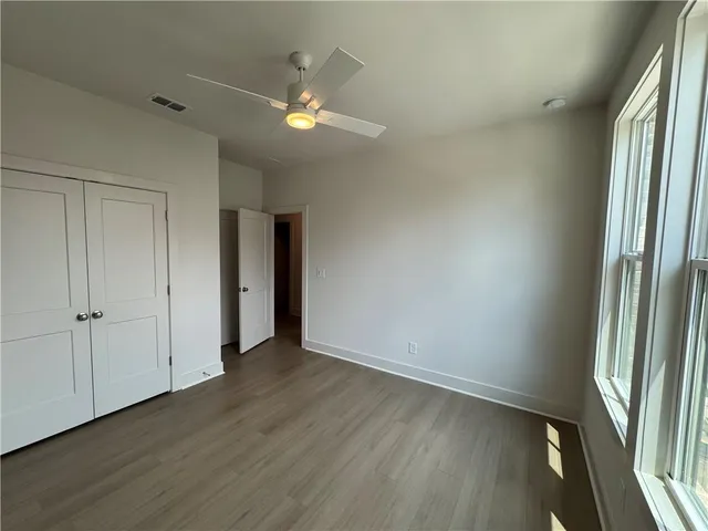 an empty room with wooden floor and window