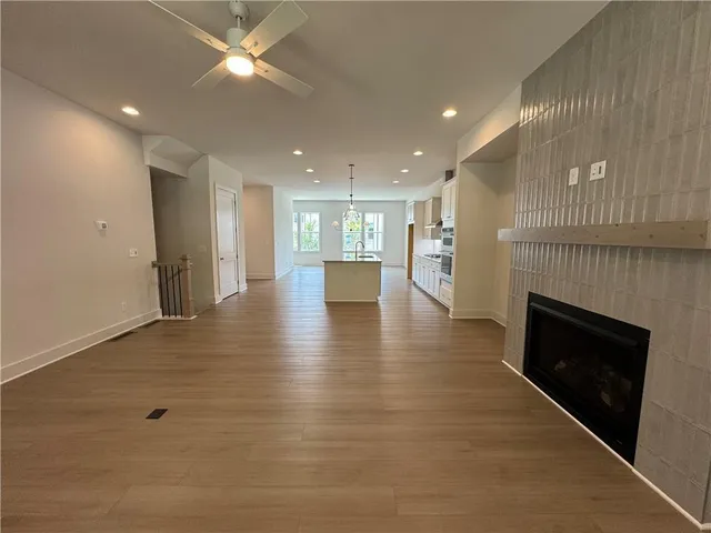 a view of an empty room and a kitchen