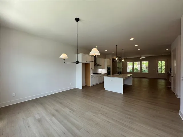 a view of a room with wooden floor and kitchen