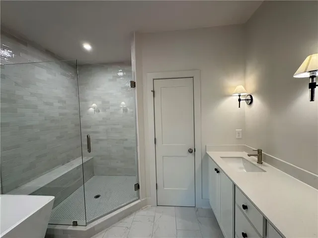 a bathroom with a shower sink and mirror