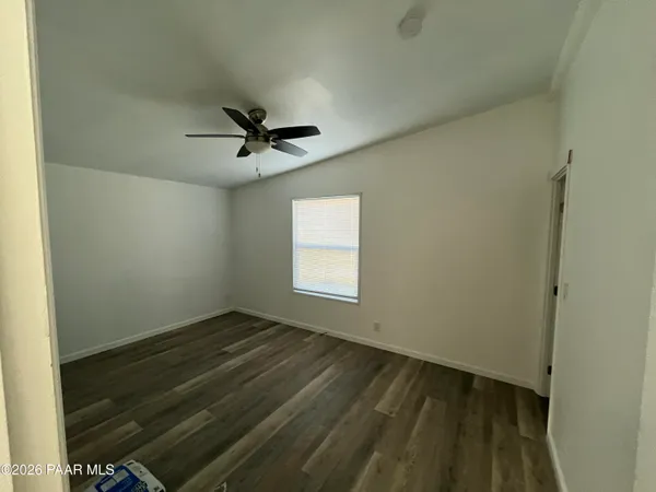 a view of empty room with window and ceiling fan