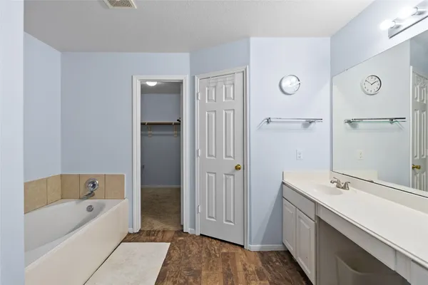 a bathroom with a tub sink and mirror