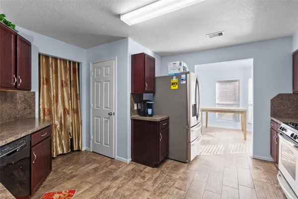 a view of a kitchen with fridge and wooden floor