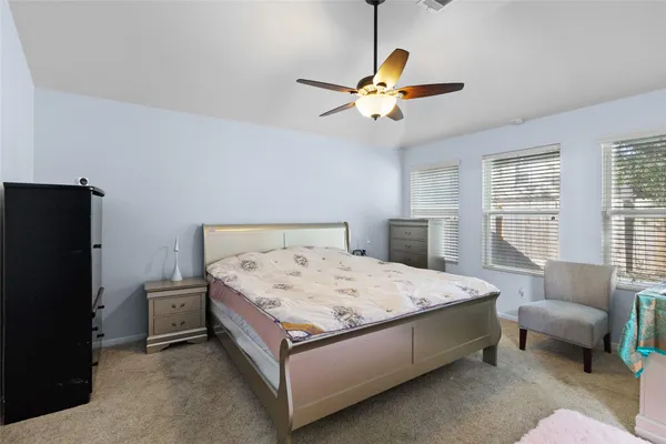 a spacious bedroom with a bed and a chandelier