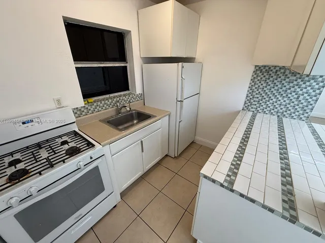 a kitchen with a stove and a refrigerator