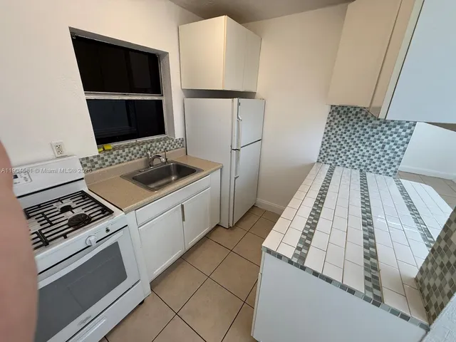 a kitchen with a stove and a refrigerator