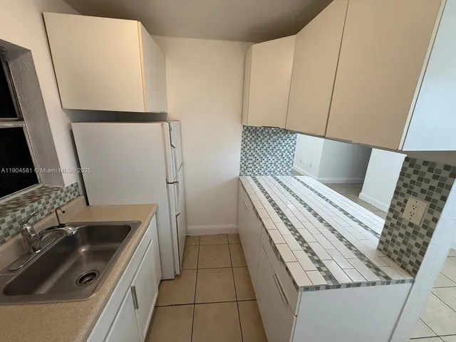 a kitchen with a sink a stove and refrigerator