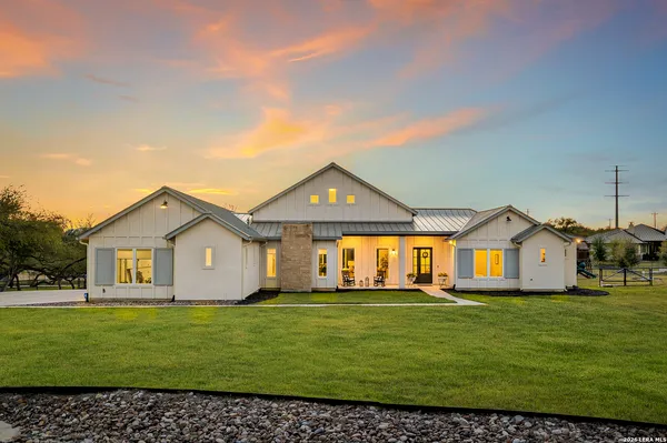 a view of a house with a big yard and large trees