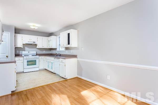 1925 Carthage Circle Raleigh, NC 27604 - Photo 4 of 15 a kitchen with granite countertop white cabinets and white appliances