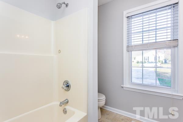1925 Carthage Circle Raleigh, NC 27604 - Photo 9 of 15 a bathroom with a bathtub a toilet and a window
