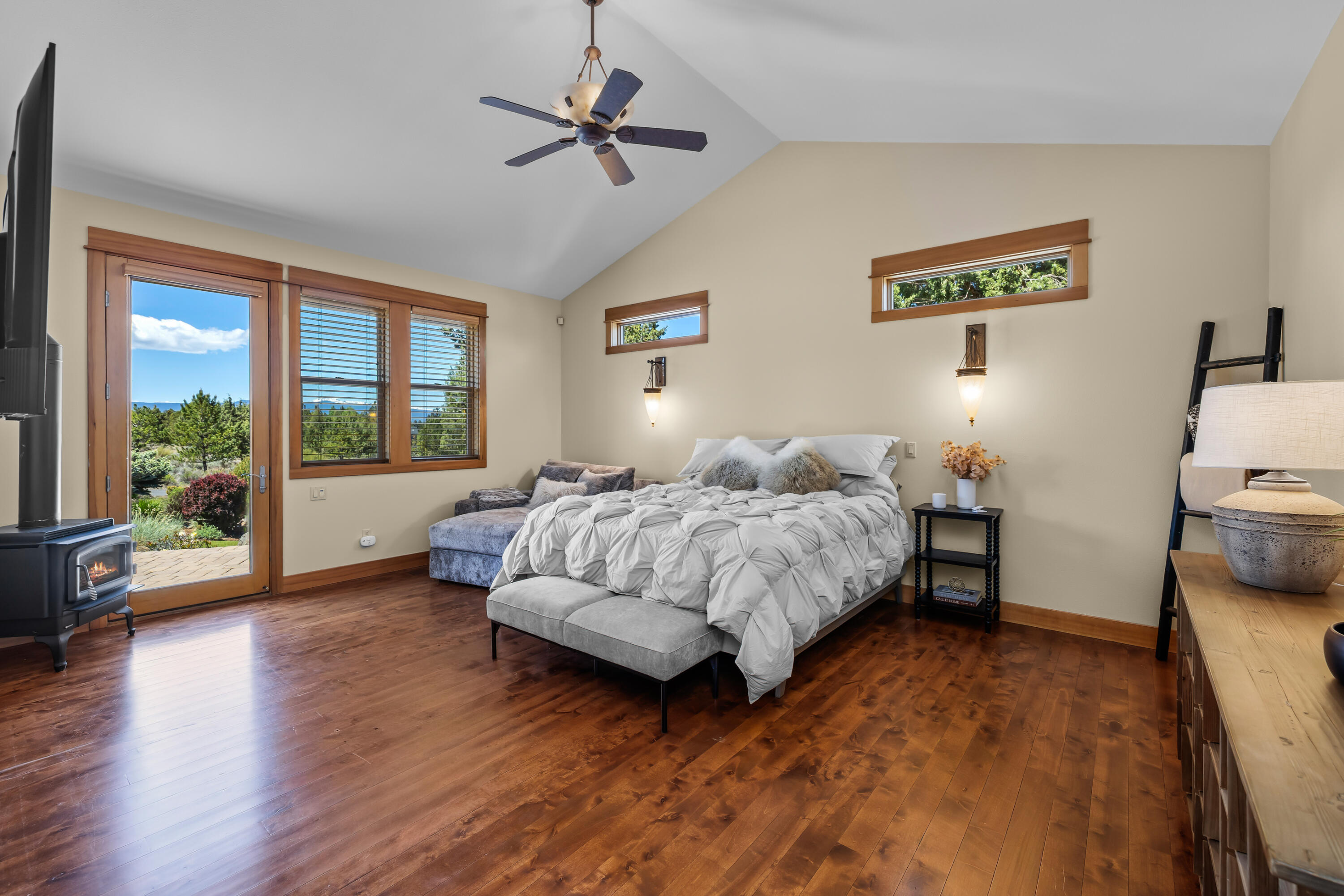 64145 Hunnell Road Bend, OR 97703 - Photo 18 of 65 Set privately on its own wing away from the guest bedrooms, the primary suite offers real wood floors, a Regency propane fireplace, and direct access to the mountain-view patio and hot tub area.