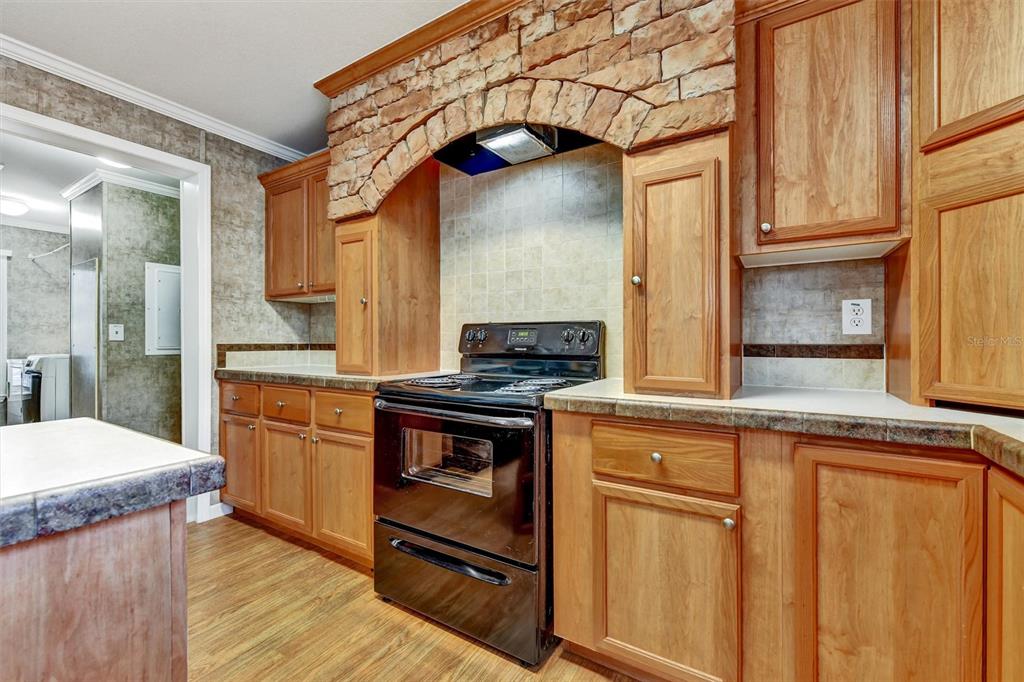 312 Aristides Street Dunedin, FL 34698 - Photo 8 of 38 a kitchen with stainless steel appliances granite countertop a stove cabinets and wooden floor