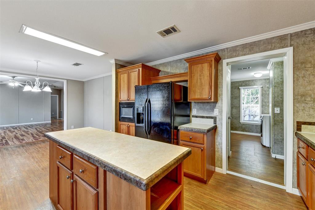 312 Aristides Street Dunedin, FL 34698 - Photo 9 of 38 a kitchen with stainless steel appliances a kitchen island hardwood floor sink stove and refrigerator