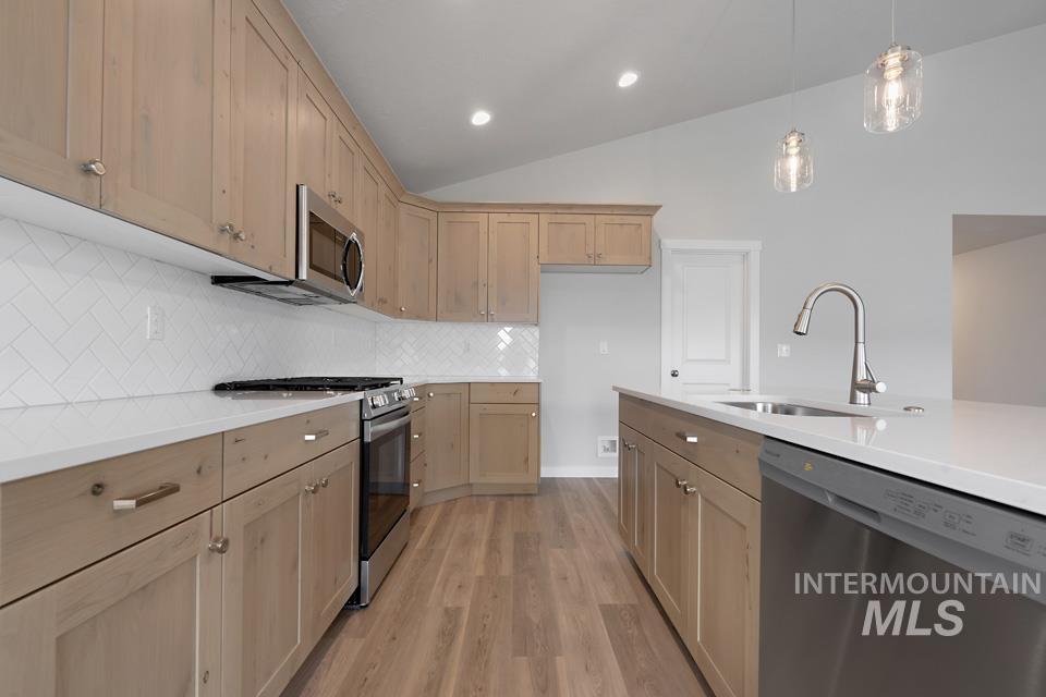 1355 Crescent Street Weiser, ID 83672 - Photo 10 of 31 Kitchen with stainless steel appliances, light wood-type flooring, light countertops, light brown cabinets, and decorative backsplash