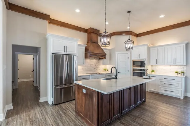 a kitchen with kitchen island granite countertop a island a sink stainless steel appliances and cabinets