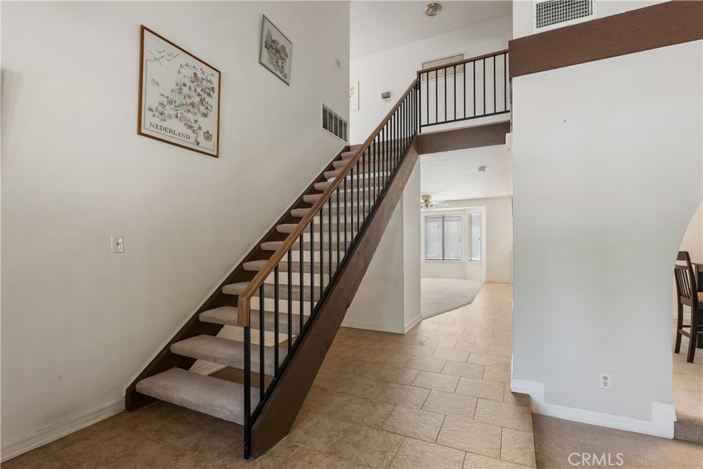 17656 Mockingbird Hill Circle Riverside, CA 92504 - Photo 15 of 49 a view of staircase with lots of frames on wall and a window