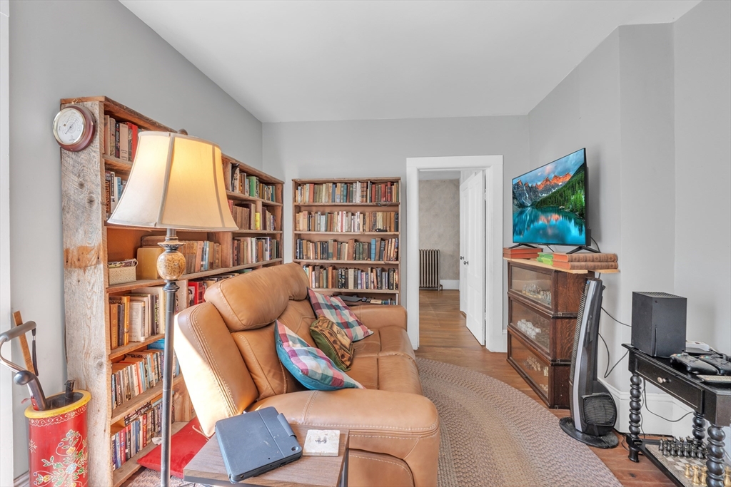 665 Thresher Road Hardwick, MA 01037 - Photo 19 of 41 a living room with furniture a flat screen tv and a bookshelf