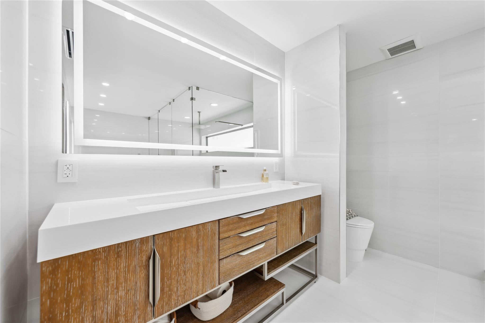 2901 Northeast 46th Street Lighthouse Point, FL 33064 - Photo 41 of 79 a bathroom with a sink a toilet and a mirror