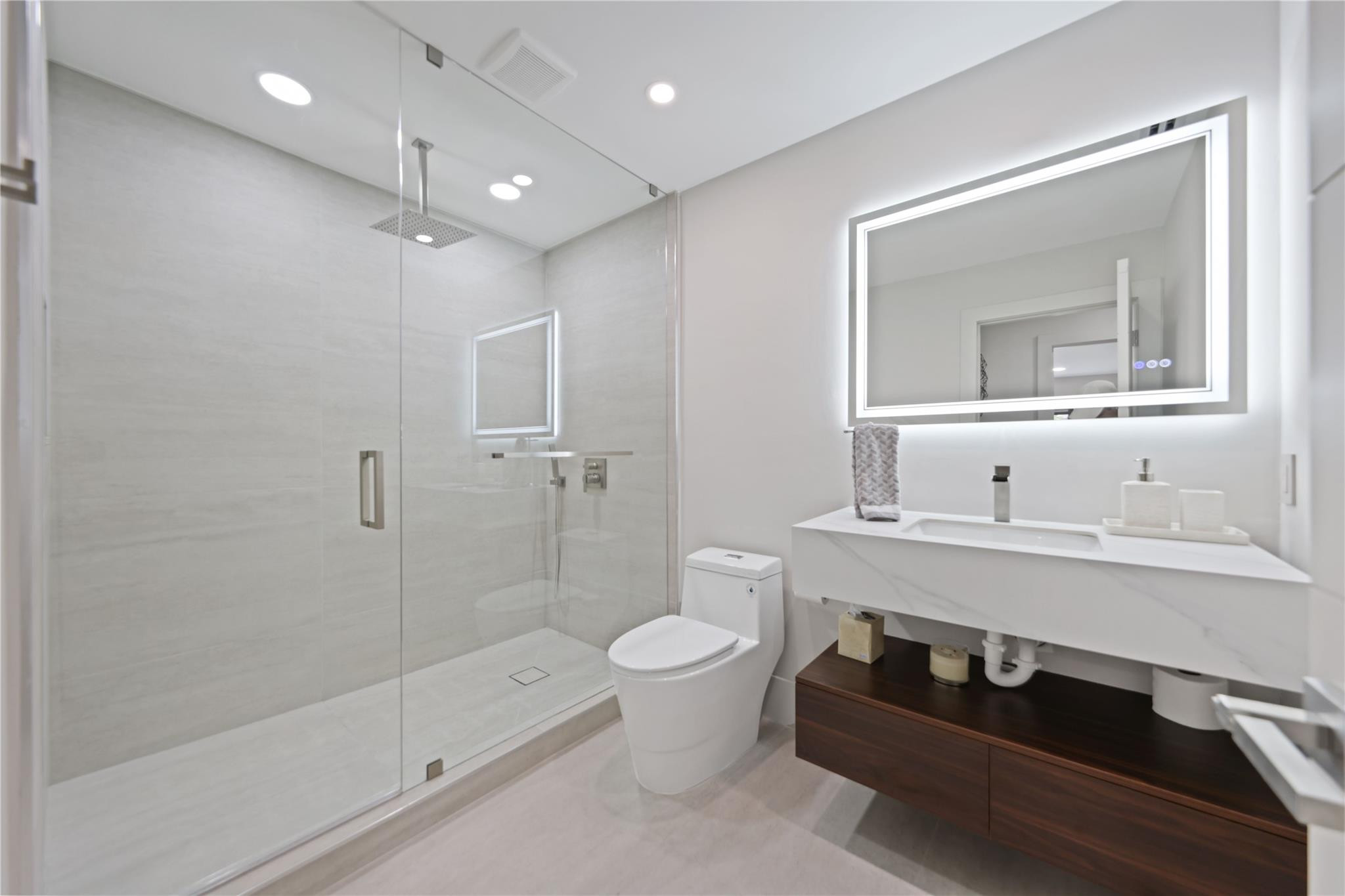 2901 Northeast 46th Street Lighthouse Point, FL 33064 - Photo 51 of 79 a bathroom with a sink a toilet a mirror and shower