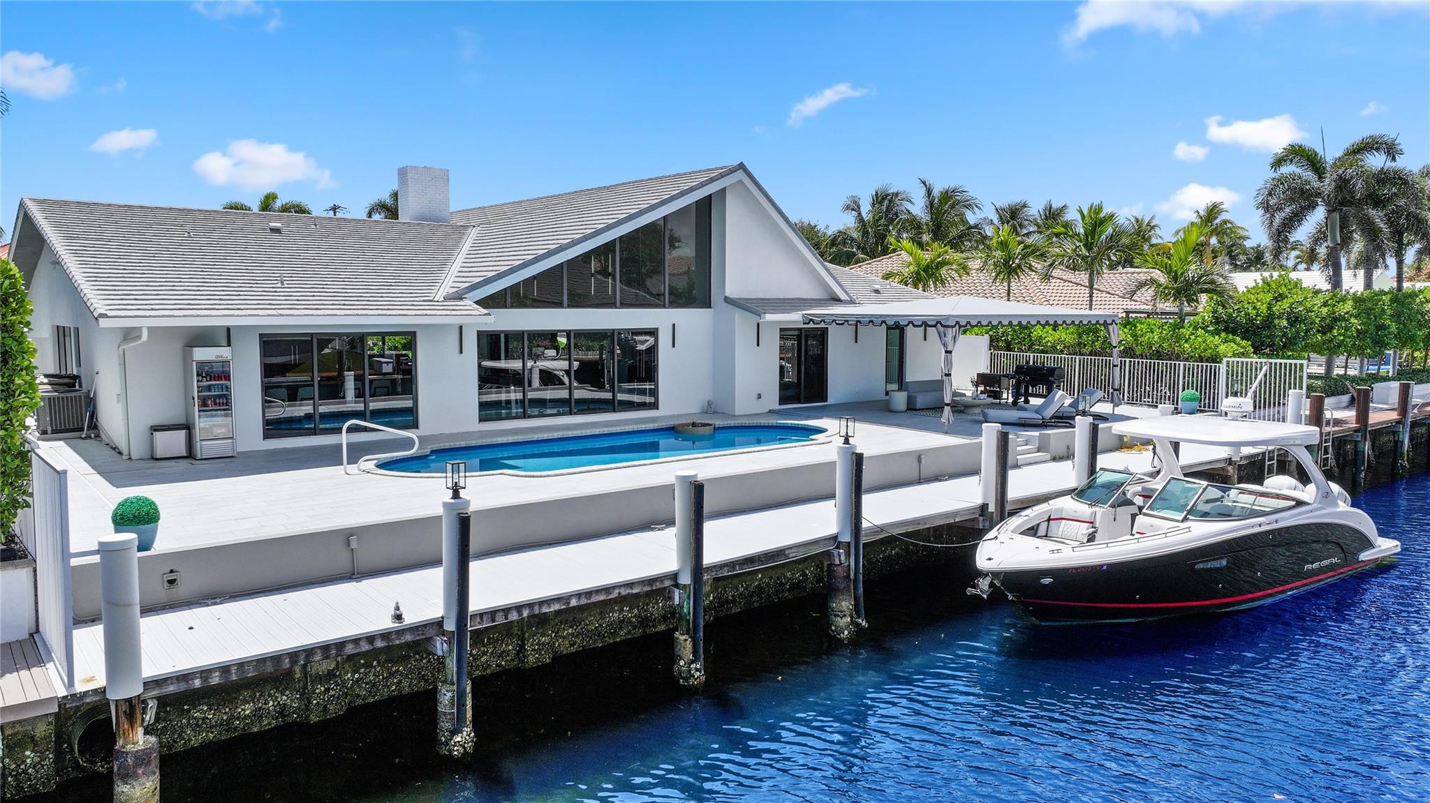 2901 Northeast 46th Street Lighthouse Point, FL 33064 - Photo 65 of 79 a view of a patio with table and chairs potted plants with wooden floor and fence