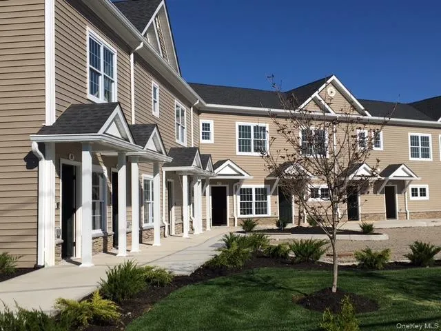 a front view of a house with a yard and trees