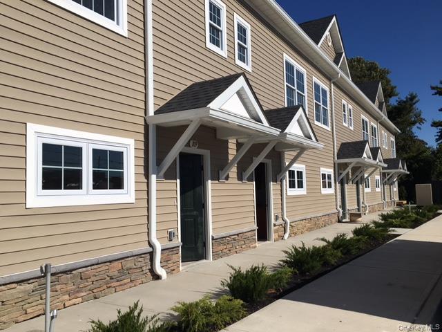 115 Evergreen Street, Unit 106 West Babylon, NY 11704 - Photo 2 of 12 a front view of a house with a yard